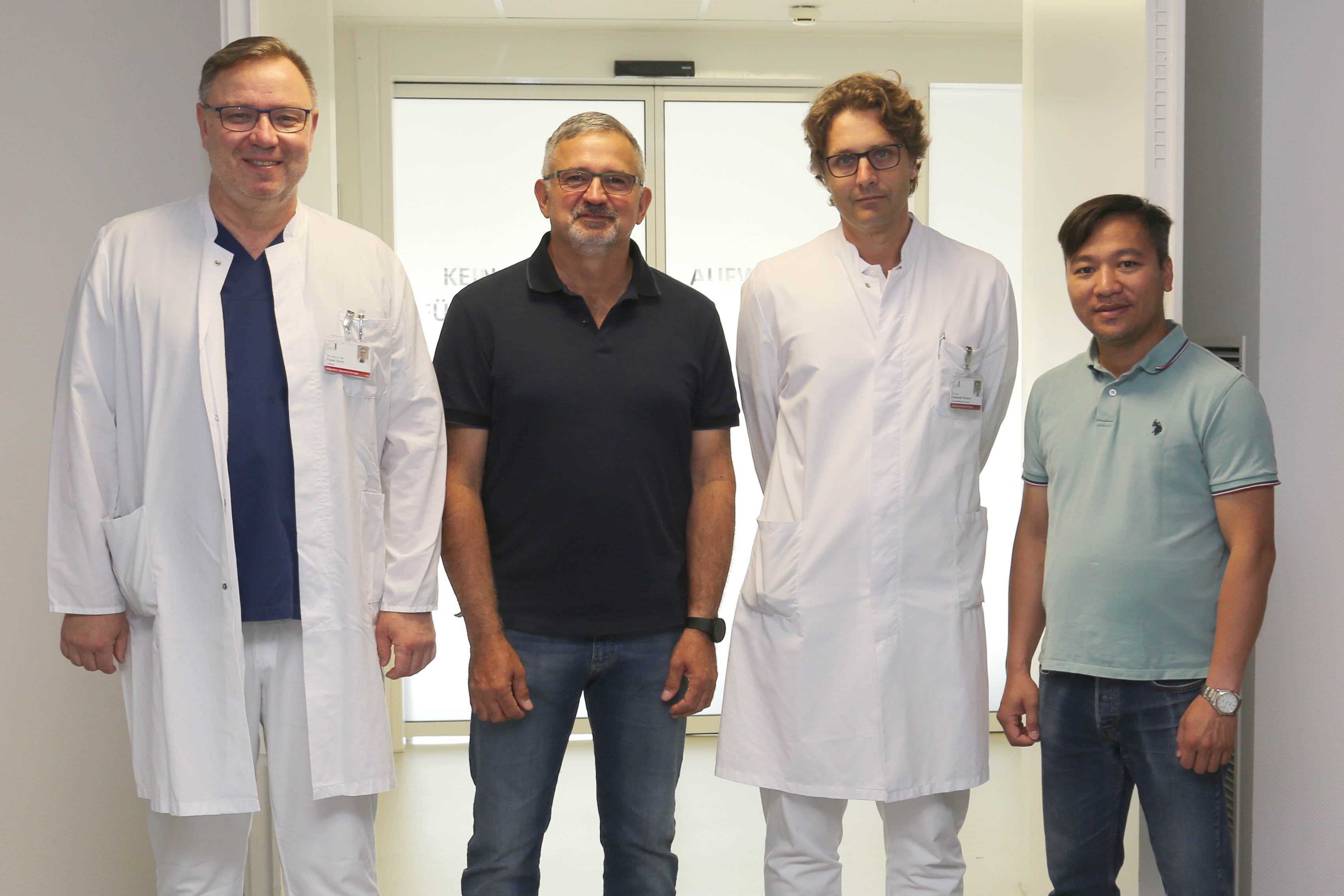 Vier Ärzte stehen auf einem Flur vor dem OP. Hospitierten bei Priv.-Doz. Dr. Frank Ulrich (links) und Dr. med. Alexander Reinisch-Liese (2.v.r.): MUDr. Ivor Dropco (2.v.l.) und  Dr. med. Dai Que Vu (rechts).