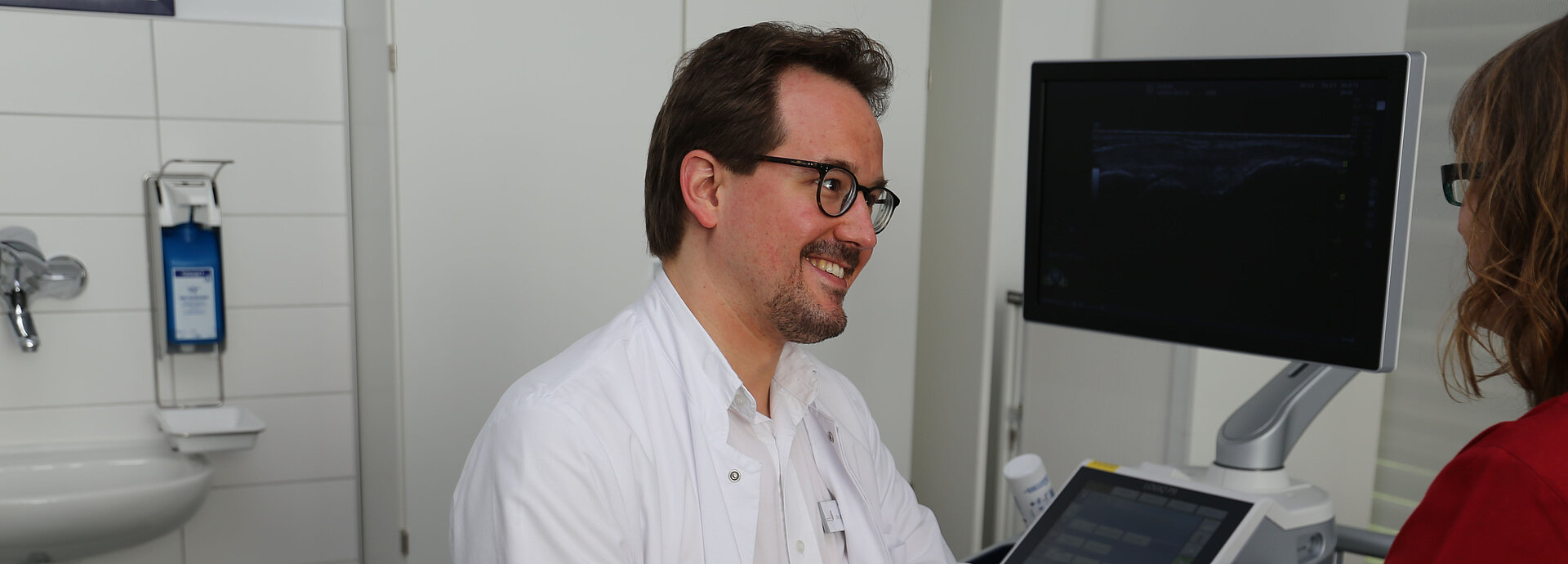 Dr. Matthias Köpf untersucht Patientin. 